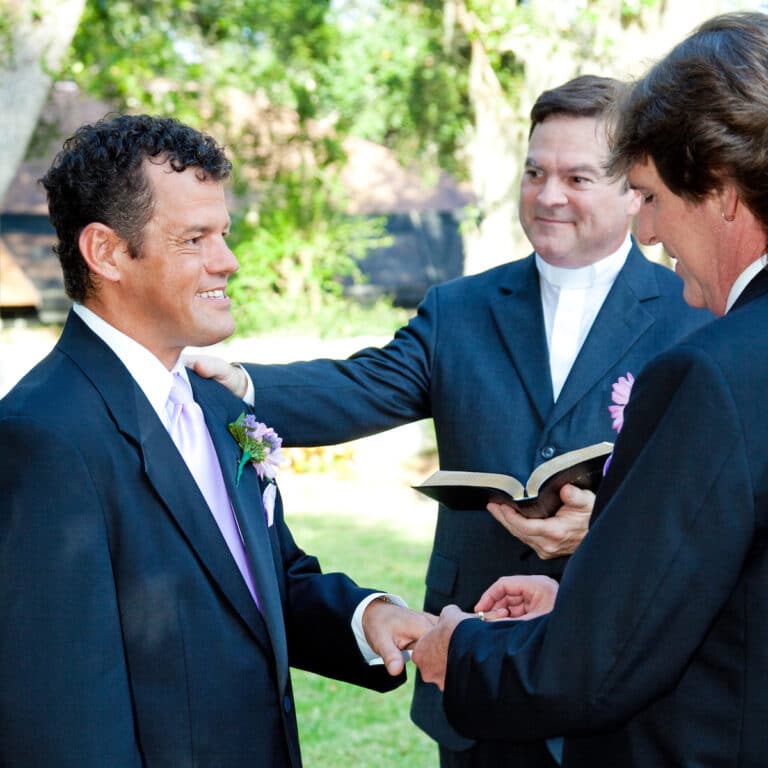 Groom slips a ring on his husband's finger during a gay marriage ceremony.