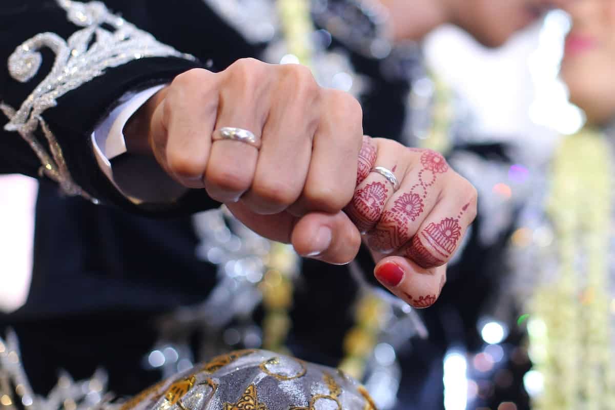 henna tattoo being applied on a women's hand.